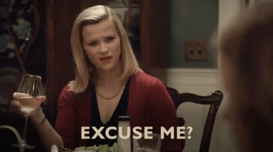 Reese Witherspoon at a dinner table with the words, "Excuse me?"