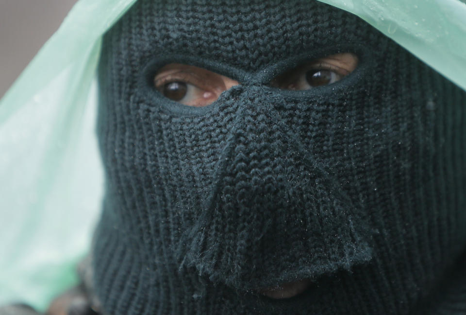 A pro-Russian gunman stands guard at a seized police station in the eastern Ukraine town of Slovyansk on Sunday, April 13, 2014. Pro-Moscow protesters have seized a number of government buildings in the east over the past week, undermining the authority of the interim government in the capital, Kiev. (AP Photo/Efrem Lukatsky)