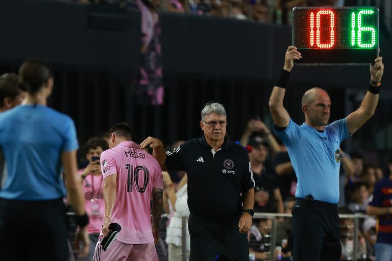 Lionel Messi deja la cancha y recibe el saludo de Tata Martino, antes de terminar el primer tiempo