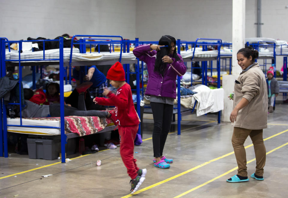 Migrants are play near bunk beds inside a government-run shelter in Ciudad Juarez, Mexico, on Sunday, Dec. 18, 2022. (AP Photo/Andres Leighton)