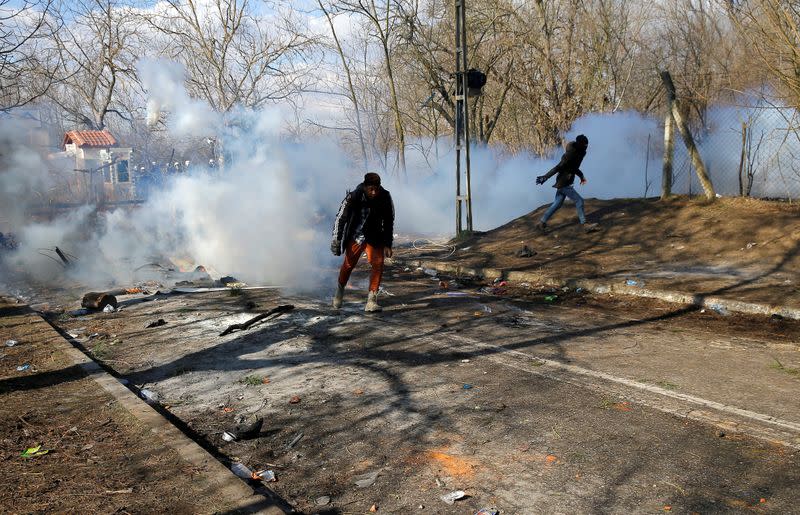 Migrants run from tear gas during clashes with Greek police, at the Turkey's Pazarkule border crossing with Greece's Kastanies, in Edirne