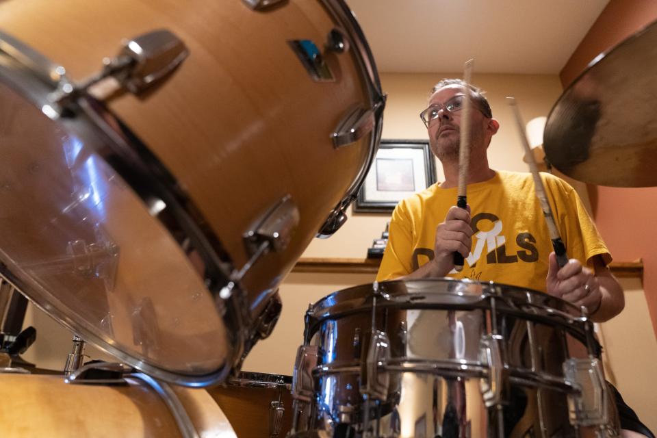 Sean Riley, a language arts teacher at DeSoto and former Seaman teacher, waits for a cue while practicing with bandmates in Untamed Mustangz Tuesday.