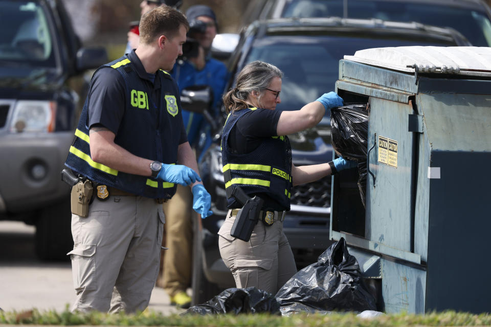 Georgia Bureau of Investigation (GBI) officers search a dumpster across the street from the Cielo Azulak Apartments, Friday, Feb. 23, 2024, in Athens, Ga. Police said Friday that they are questioning a “person of interest” in the death of a nursing student whose body was found on the University of Georgia campus after not returning from a run.(Jason Getz/Atlanta Journal-Constitution via AP)