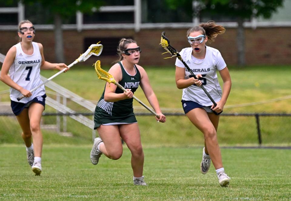 Elizabeth Ireland of Hamilton-Wenham controls the ball while pressured by Fallon Lozano of Nipmuc Regional during the MIAA Division 4 girls lacrosse state tournament game at Hamilton Wenham High School, Wednesday, June 7, 2023. Hamilton-Wenham defeated Nipmuc Regional 16-8.