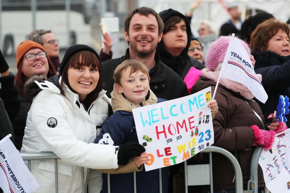 Families wave at their relatives from the jetty (PA)