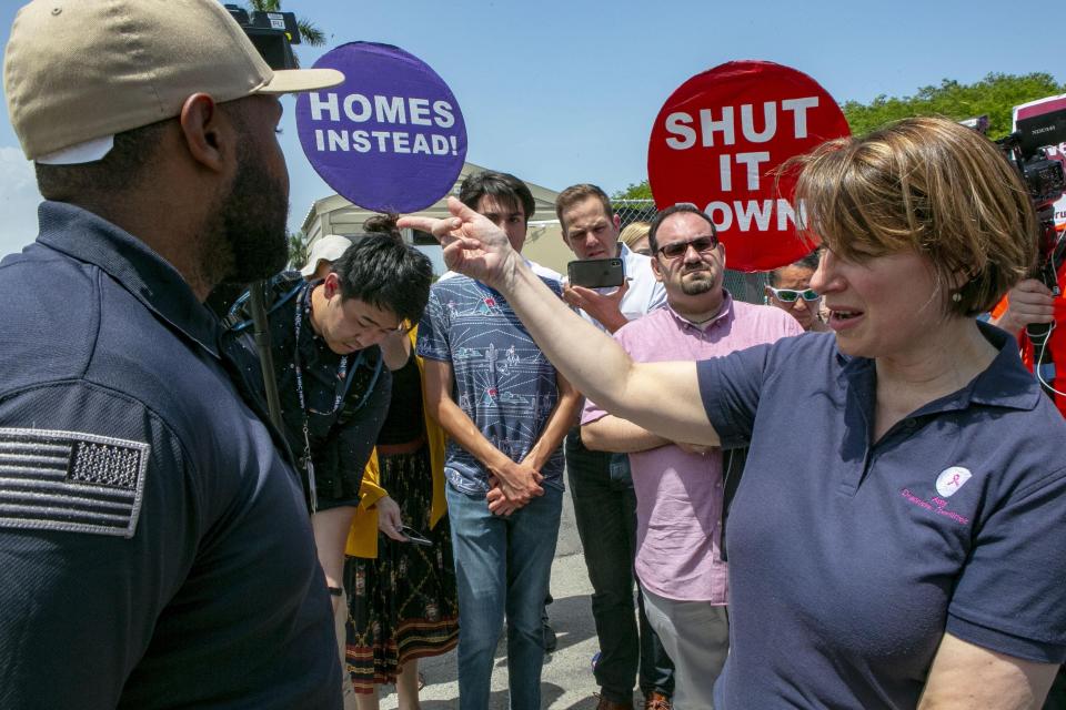 Democratic presidential candidate Amy Klobuchar requests to be let in into the Homestead Detention Center during a visit ahead of the first Democratic Debates, in Homestead, Fla. Wednesday June 26, 2019. (Daniel A. Varela/Miami Herald via AP)