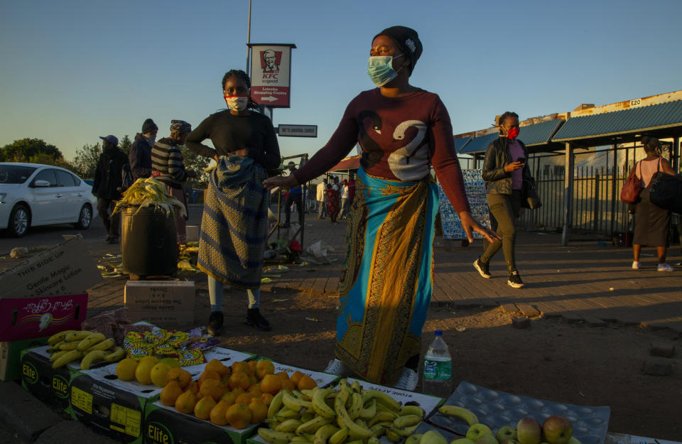 Street vendors, wearing face masks as a precaution against the spread of the new coronavirus, sell fruit on the street corner in Katlehong, east of Johannesburg, South Africa, Wednesday, May 6, 2020. South Africa began a phased easing of its strict lockdown measures on May 1, and its confirmed cases of coronavirus continue to increase as more people are being tested. (AP Photo/Themba Hadebe)