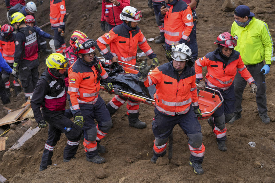 Rescue workers recover the remains of a child in Alausi, Ecuador, Tuesday, March 28, 2023, the day after a landslide swept through the town burying dozens of homes. (AP Photo/Dolores Ochoa)