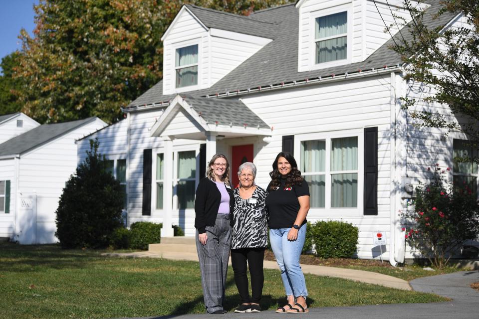 Isaiah 117 House program coordinators, from left, Mariah Sybert, Jody Hayes, and Taylor Forbes, pose for a photo in front of the house In Elizabethton, Tenn., Thursday, Oct. 12, 2023. Isaiah 117 House provides a welcoming place for children removed from their homes by the Department of Children's Services, but who are still waiting to be placed in foster care.