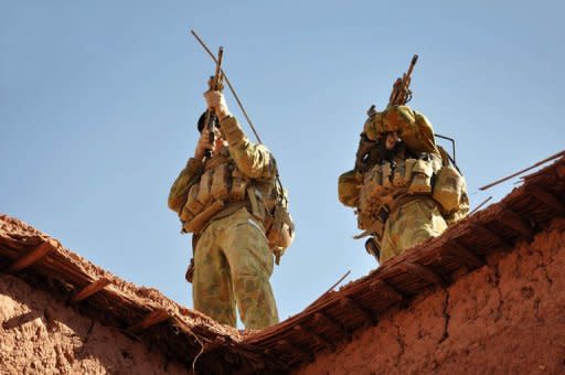 Australian soldiers use their rifle scopes to survey the surrounding mountains during an operation in southern Afghanistan. Australia will bring its troops home from Afghanistan a year earlier than planned with most soldiers withdrawn in 2013, Prime Minister Julia Gillard said Tuesday