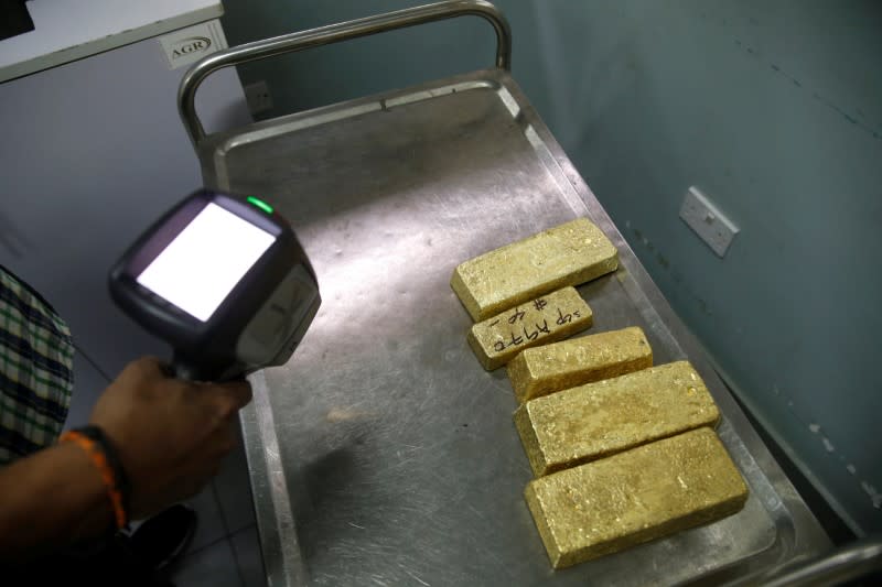 An employee uses a precious metals analyser on gold bars at AGR (African Gold Refinery) in Entebbe