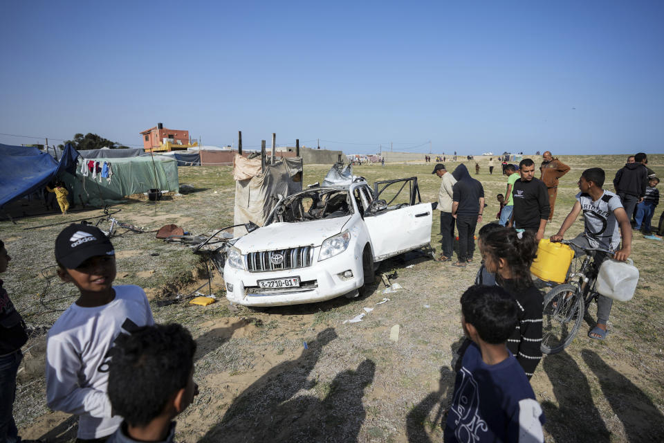 People inspect the site where World Central Kitchen workers were killed in Deir al-Balah, Gaza Strip, Tuesday, April 2, 2024. World Central Kitchen, an aid group, says an Israeli strike that hit its workers in Gaza killed at least seven people, including several foreigners. (AP Photo/Abdel Kareem Hana)