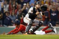 Boston Red Sox's Mookie Betts, left, scores the walk-off run on a single by Rafael Devers as Baltimore Orioles' Austin Wynns waits for the throw during the ninth inning of a baseball game in Boston, Sunday, Sept. 29, 2019. (AP Photo/Michael Dwyer)