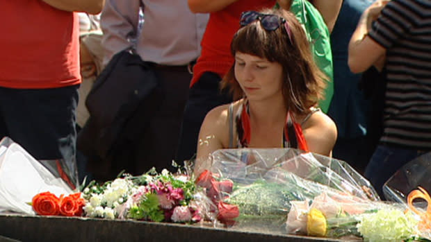 A lone mourner pays her respects to NDP leader Jack Layton at the Centennial Flame on Parliament Hill. Layton died of cancer at his Toronto home early Monday morning.