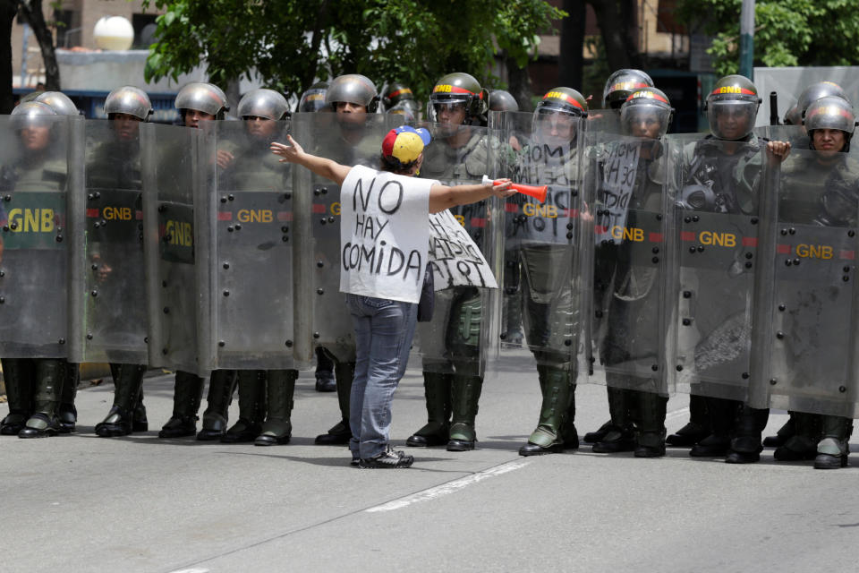 An opposition supporter carrying a banner that reads "There is not food" shouts to members of the Venezuelan National Guard during clashes in a rally to demand a referendum to remove President Nicolas Maduro in Caracas on May 18, 2016.&nbsp;