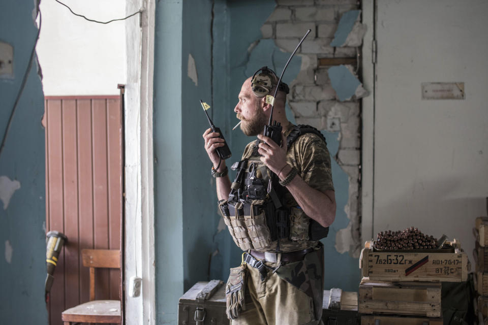 Un soldado ucraniano sostiene dos radios durante intensos combates en la línea del frente en Severodonetsk, en la región de Luhansk, Ucrania, el 8 de junio de 2022. (AP Foto/Oleksandr Ratushniak)