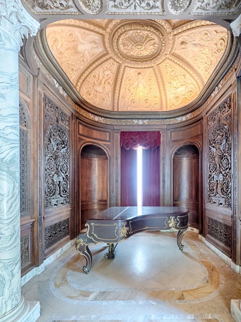 With carved wood-paneled walls, swirled marble columns, and a majestic domed ceiling, this alcove is fit for a grand piano.