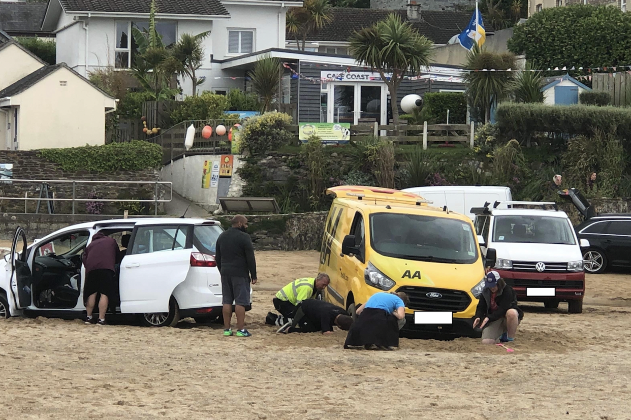 An AA van is stuck next to the car it was supposed to rescue on a beach at Newquay, Cornwall. (Reach)