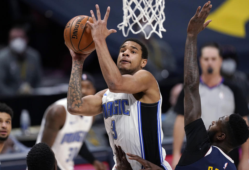 Orlando Magic forward Chuma Okeke drives to the basket and draws a foul from Denver Nuggets forward JaMychal Green during the first half of an NBA basketball game Sunday, April 4, 2021, in Denver. (AP Photo/David Zalubowski)