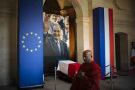 A monk walks past by the coffin of late French President Jacques Chirac, Sunday, Sept. 29, 2019 at the Invalides monument in Paris. Jacques Chirac will lie in state Sunday during a public ceremony at the Invalides monument, where France honors its heroes. A memorial service and private funeral are planned for Monday. (AP Photo/Kamil Zihnioglu)