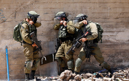 Israeli soldiers take cover during clashes with Palestinians at a protest near the Jewish settlement of Qadomem, in village of Kofr Qadom near Nablus in the occupied West Bank August 17, 2018. REUTERS/Mohamad Torokman