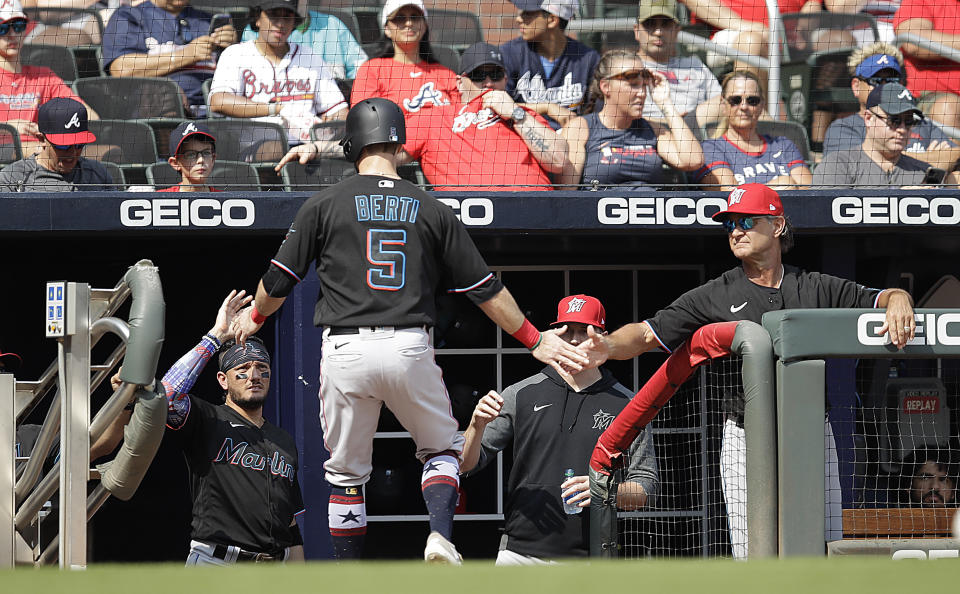 Miami Marlins' Jon Berti (5) is congratulated by manager Don Mattingly, right, after scoring against the Atlanta Braves in the third inning of a baseball game Saturday, July 3, 2021, in Atlanta. Berti scored on a single by Marlins' Jazz Chisholm Jr. (AP Photo/Ben Margot)
