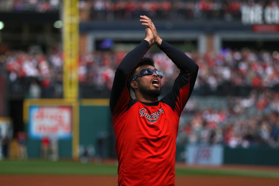 Gabriel Arias #13 of the Cleveland Guardians looks up at the total solar eclipse before the home opener against the Chicago White Sox at Progressive Field on April 08, 2024 in Cleveland, Ohio.