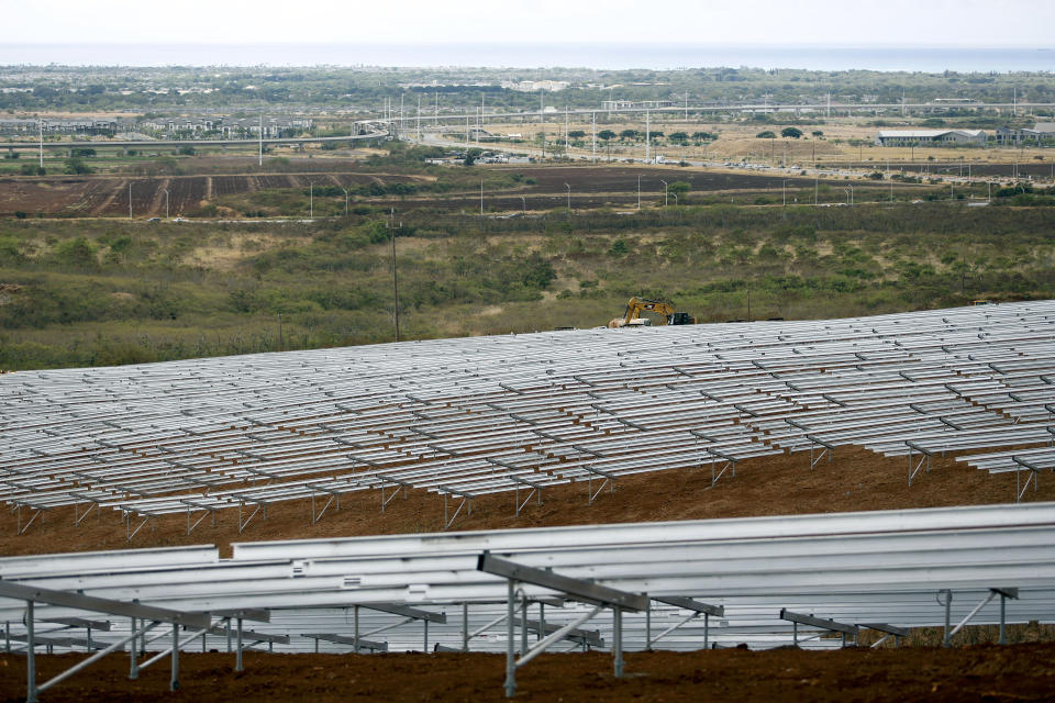 Construction crews work on unfinished racks for solar panels at the AES Corporation's West Oahu solar farm in Kapolei, Hawaii, Tuesday, Aug. 23, 2022. As Hawaii transitions toward it goal of achieving 100% renewable energy by 2045, the state's last coal-fired power plant closed this week ahead of a state law that bans the use of coal as a source of electricity beginning 2023. (AP Photo/Caleb Jones)