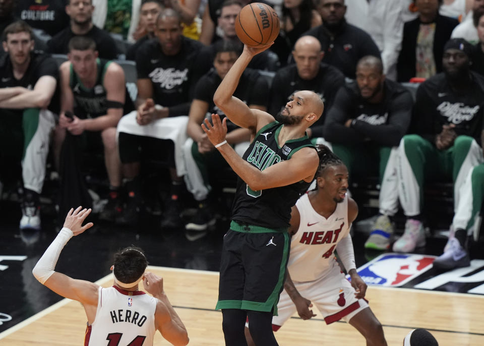 Boston Celtics guard Derrick White (9) scores over Miami Heat guard Tyler Herro (14) during the first half of Game 4 of an NBA basketball first-round game, Monday, April 29, 2024, in Miami. (AP Photo/Marta Lavandier)