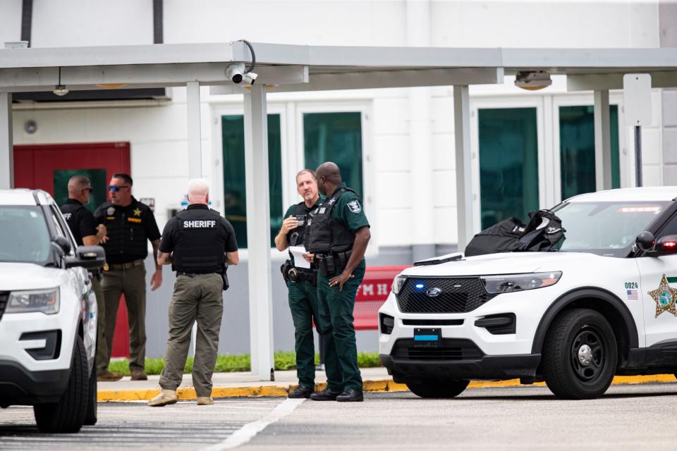 Members of the Lee County SheriffÕs Office stand in front of the school after a threat of a gun was called in Friday afternoon. Lee County SheriffÕs Office declared that there was no active shooter after officers searched the school.