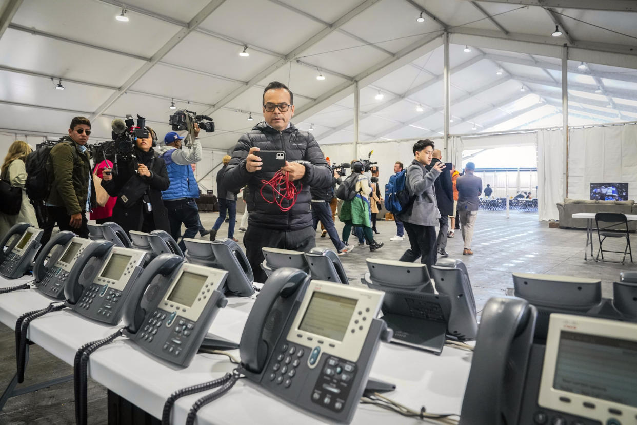 A phone bank center to make international calls, shown during a media tour, is part of New York City's latest temporary shelter on Randall's Island for migrants being bused into the city by southern border states, Oct. 18, 2022, in New York. The shelter will start taking in single adult men on Wednesday, Oct. 19, with facilities including laundry, regular meals and a mass sleeping area. (AP Photo/Bebeto Matthews)
