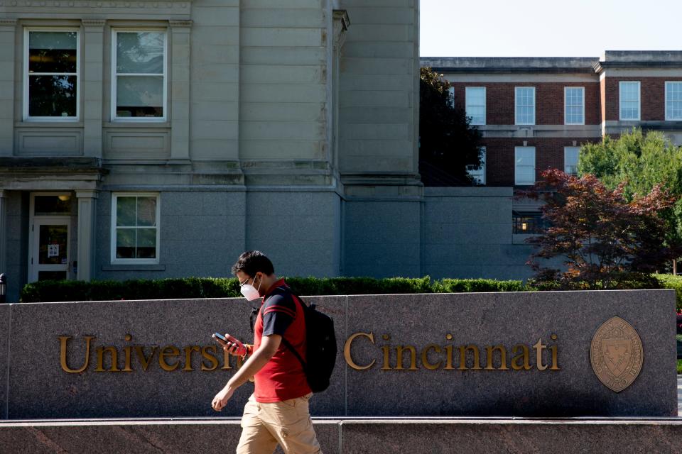 A student walks past the University of Cincinnati sign on the UC campus on Monday, Aug. 23, 2021.