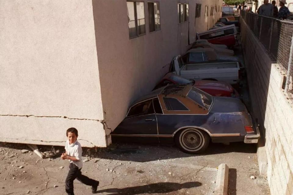 Vehicles crushed when a soft-story apartment building collapsed during the Northridge earthquake in 1994.