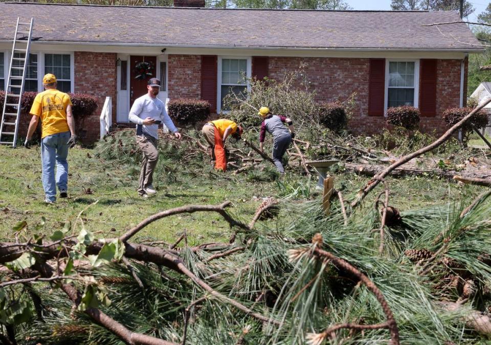 Volunteers with the South Carolina Baptist Convention Disaster Relief group help clean up a yard Wednesday on Post Lane in Rock Hill.