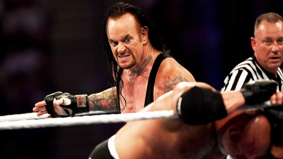 The Undertaker, Mark Calaway, sets up for the chokeslam.