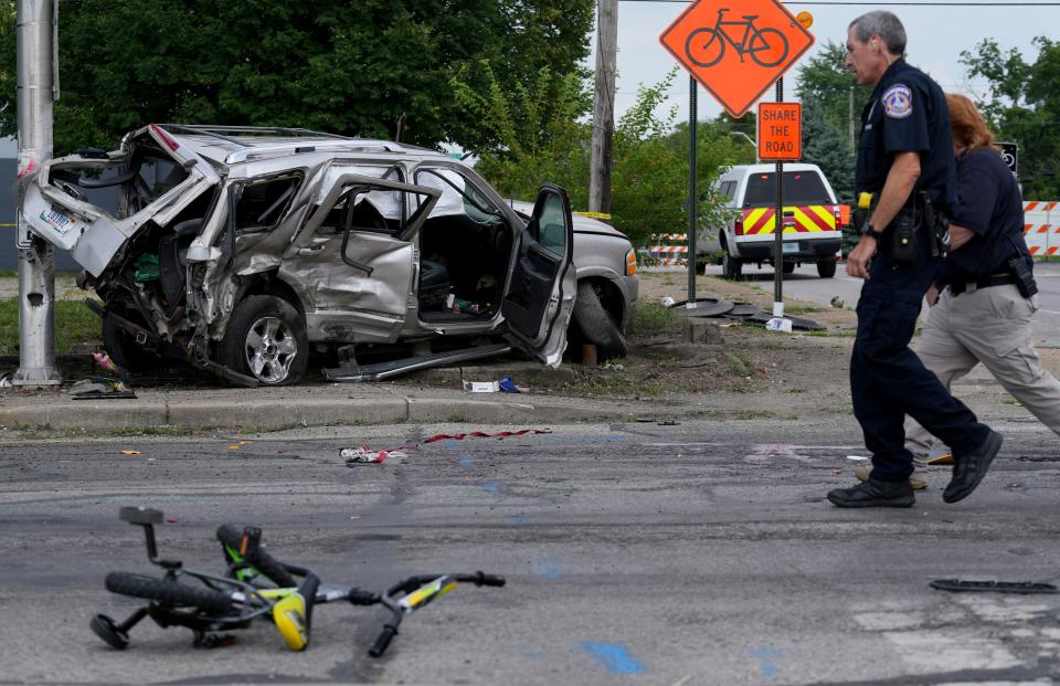 Law enforcement officials work the scene of an accident that officials say left left six kids and two adults injured on Tuesday, July 23, 2024, near the intersection of North State Avenue and East New York Street in Indianapolis.