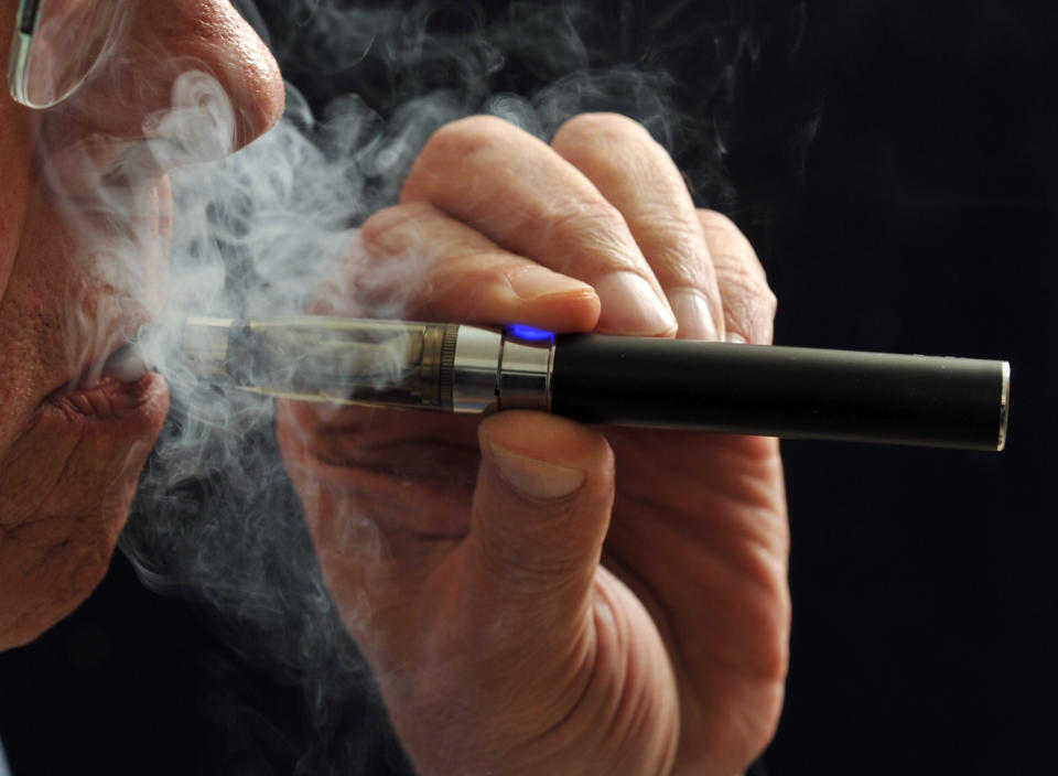 FILE - In this Jan. 17, 2014 file photo, a smoker demonstrates an e-cigarette in Wichita Falls, Texas. Soon, the Food and Drug Administration will propose rules for e-cigarettes. The rules will have big implications for a fast-growing industry and its legions of customers. (AP Photo/Wichita Falls Times Record News, Torin Halsey, File)