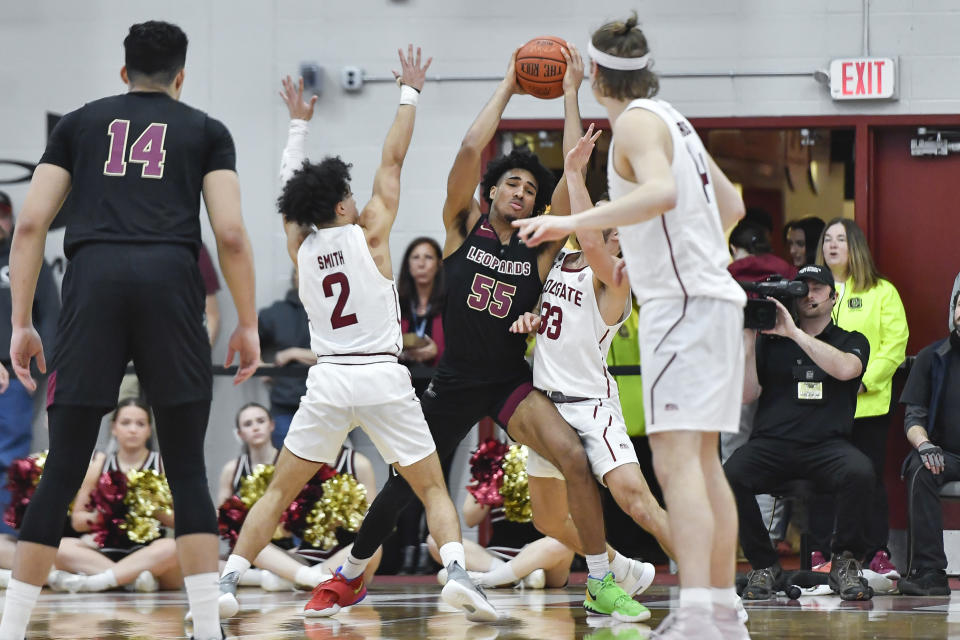 Lafayette forward Josh Rivera (55) is defended by Colgate guards Braeden Smith (2) and Oliver Lynch-Daniels (33) during the first half of an NCAA college basketball game for the Patriot League tournament championship in Hamilton, N.Y., Wednesday, March 8, 2023. (AP Photo/Adrian Kraus)