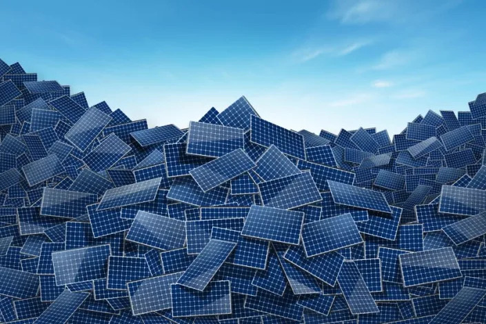 Illustration of solar panels discarded into large piles with the sky behind them.