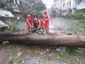 This photograph provided by India's National Disaster Response Force (NDRF) shows NDRF personnel a tree that feel down amid heavy rain and winds at Mahuva town in Bhavnagar District, in Gujarat state, India, Tuesday, May 18, 2021. Cyclone Tauktae that emerged in the Arabian Sea made landfall on India's western coast on Monday, hours after authorities evacuated hundreds of thousands of people and suspended COVID-19 vaccinations in one state. (National Disaster Response Force via AP)