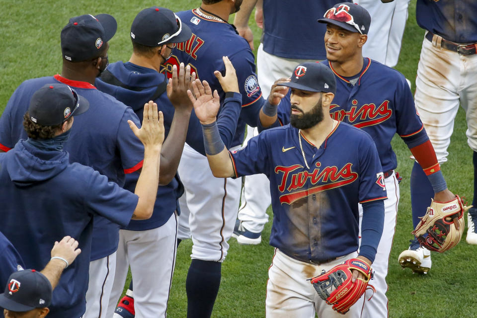 El venezolano Marwin González (adelante) y el dominicano Jorge Polanco festejan con el resto de los Mellizos de Minnesota, tras barrer a los Tigres de Detroit en una doble cartelera, el viernes 4 de septiembre de 2020 (AP Foto/Bruce Kluckhohn)