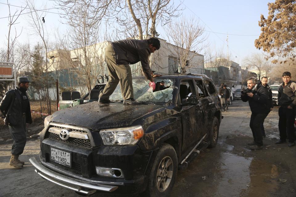 An Afghan driver removes a broken windshield of his car following the Friday's suicide attack and shooting in Kabul, Afghanistan, Saturday, Jan. 18, 2014. A Taliban suicide bomber and two gunmen on Friday attacked a Lebanese restaurant that is popular with foreigners and affluent Afghans in Kabul, a brazen attack that left 16 dead, including foreigners dining inside and two other gunmen, officials said. (AP Photo/Rahmat Gul)