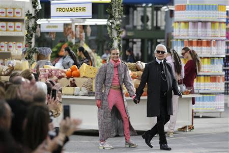 German designer Karl Lagerfeld (R) and model Cara Delevingne appear at the end of his Fall/Winter 2014-2015 women's ready-to-wear collection show for French fashion house Chanel at the Grand Palais transformed into a "Chanel Shopping Center" during Paris Fashion Week March 4, 2014. REUTERS/Stephane Mahe