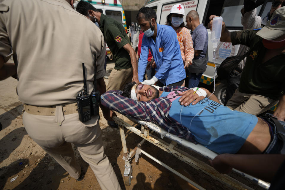 A passenger injured in a bus accident in Jammu and Kashmir's Poonch district is brought for treatment at a hospital in Jammu, India, Wednesday, Sept.14, 2022. Nearly a dozen people died and more people were injured when a mini-bus plunged into a deep gorge Wednesday. (AP Photo/Channi Anand)