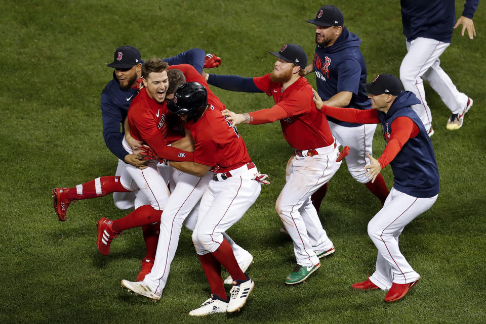 The Boston Red Sox celebrate after beating the Tampa Bay Rays on a sacrifice fly ball by Enrique Hernandez (5) during the ninth inning during Game 4 of a baseball American League Division Series, Monday, Oct. 11, 2021, in Boston. The Red Sox won 6-5. (AP Photo/Michael Dwyer)