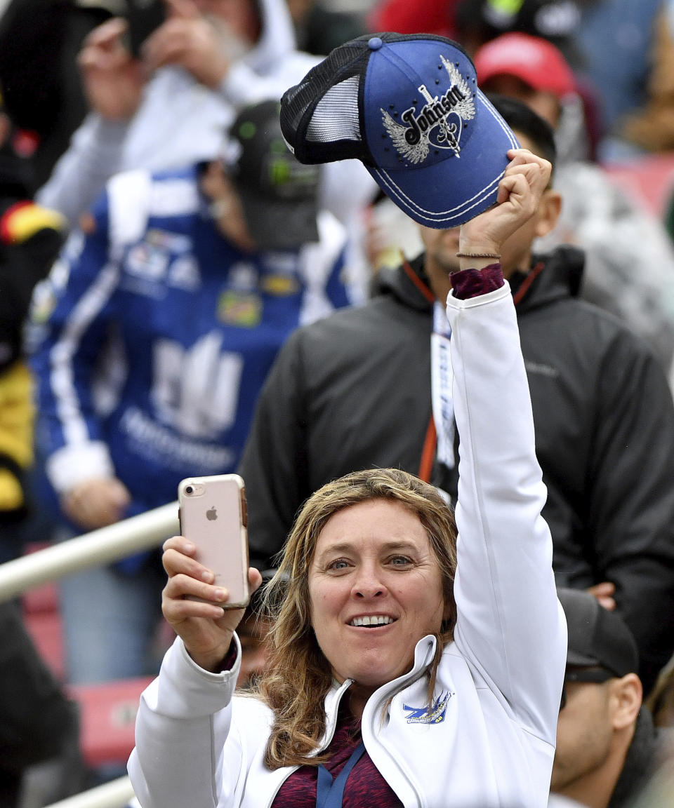 FILE - A Jimmie Johnson fan waves her cap during introductions prior to a NASCAR Cup Series auto race Sunday, March 1, 2020, in Fontana, Calif. Seven-time NASCAR champion Jimmie Johnson is returning to NASCAR two years after his retirement from the stock car series. (AP Photo/Will Lester)