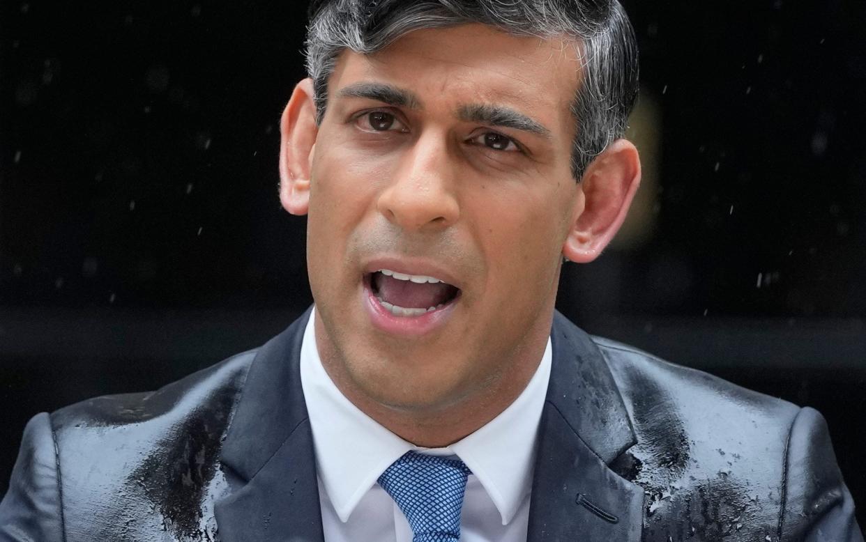 Prime Minister Rishi Sunak speaks to the media, as heavy rain falls, outside 10 Downing Street in London