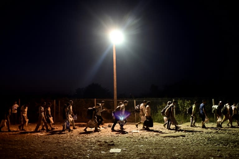 A group of migrants walks to catch a train after crossing the border from Greece to Macedonia at the village of Gevgelija on August 29, 2015