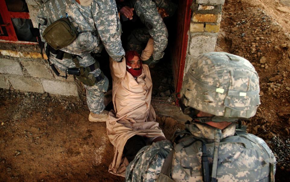 Paratroopers, from Company C, First Battalion, 505th Parachute Infantry Regiment, give medical assistance to a wounded Iraqi man in a empty home in the village of Jadida, Iraq, Feb. 10, 2007, The man was shot with a warning shot by paratroopers after he failed to stop his vehicle. The man received minor wounds to his legs and was transported to a military hospital, after medics patched him up on the scene. The paratroopers were in the village looking for weapons caches.