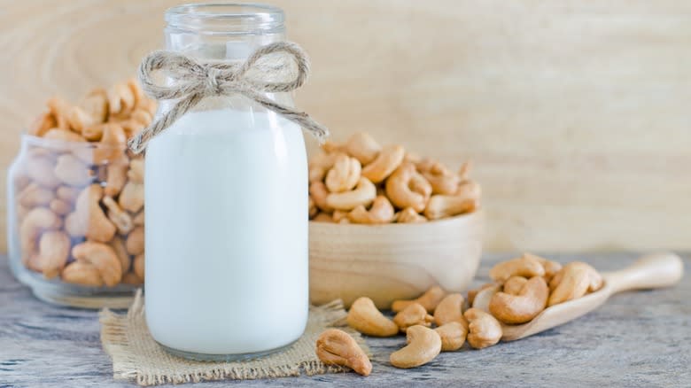 A bottle of cashew milk next to cashews